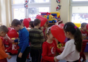 Dzieci uczestniczące w zabawie tanecznej z balonami.